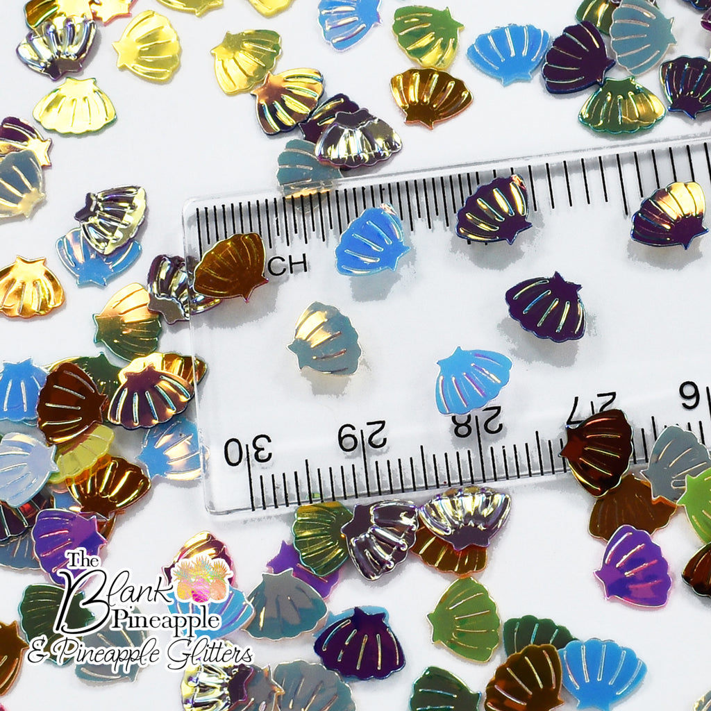 Iridescent PVC seashell-shaped confetti, 2oz bag (56g), perfect for crafts, decor, and parties with a shimmering ocean-inspired finish. - The Blank Pineapple