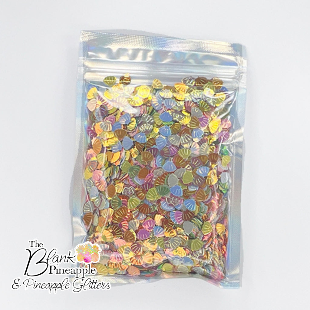 Iridescent PVC seashell-shaped confetti, 2oz bag (56g), perfect for crafts, decor, and parties with a shimmering ocean-inspired finish. - The Blank Pineapple