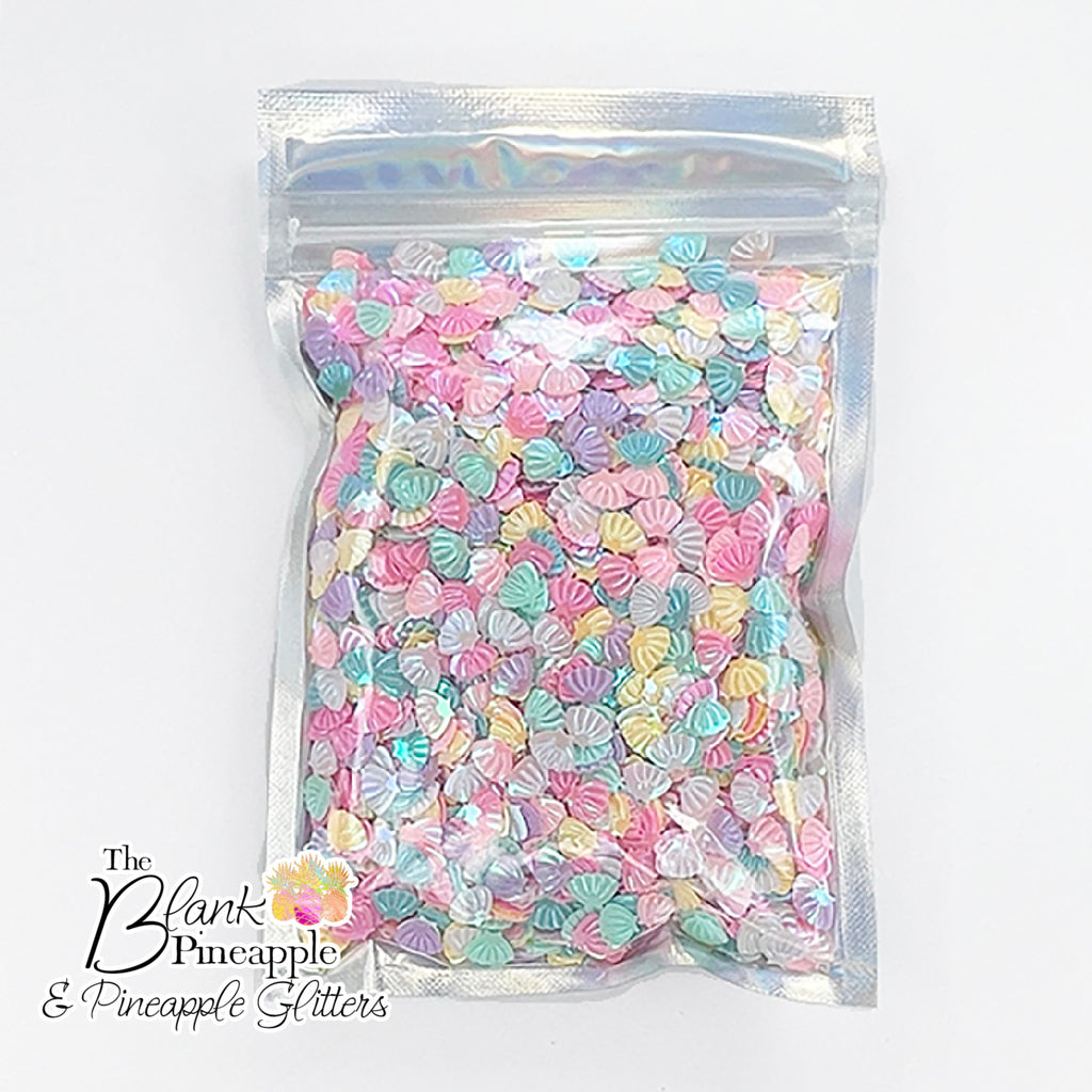 Iridescent PVC seashell-shaped confetti, 2oz bag (56g), perfect for crafts, decor, and parties with a shimmering ocean-inspired finish. - The Blank Pineapple